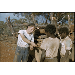 134034PD: David Smith paying Aborigines for collecting sandalwood at Cundeelee, May 1957