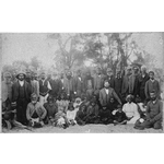 253420PD: Group portrait of Noongar men, women, and children. Fanny Balbuk sitting front row, second from right. Before 1907.
