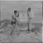 363672PD: Two men with a sign warning of nuclear radiation, Montebello Islands, Western Australia, 1956?
