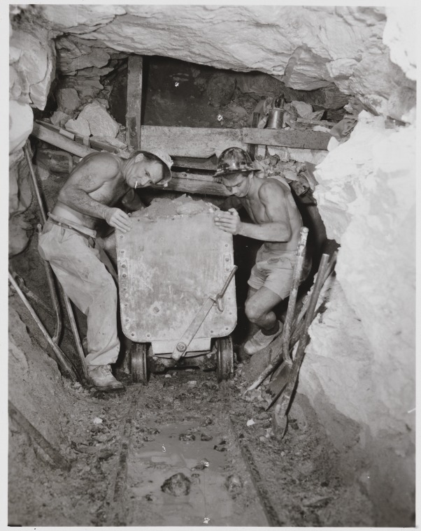 Asbestos miners Jack Trinidad (left) and Jim Edmonds pushing cart down