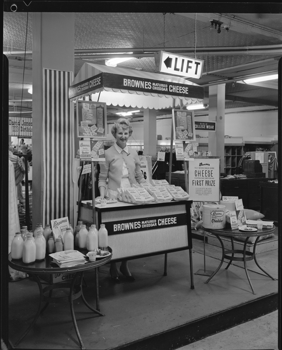 A woman in David Jones with a display for Brownes Matured Cheese and