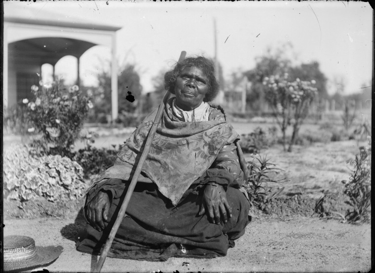 Aboriginal Australian woman, probably Kitty Notuman, outside F.M. House ...