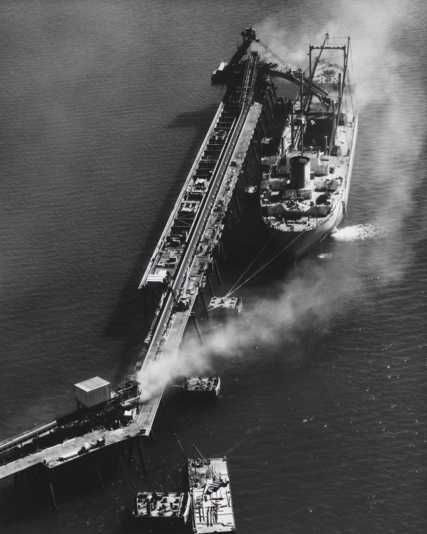 Aerial photographs of iron ore being loaded into the holds of the ...